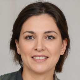 Joyful white adult female with medium  brown hair and brown eyes