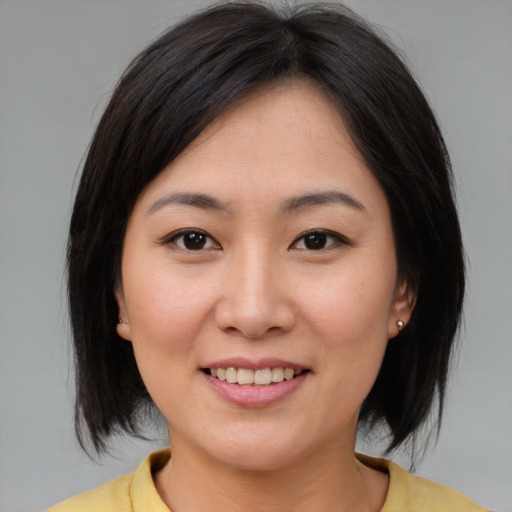 Joyful asian young-adult female with medium  brown hair and brown eyes