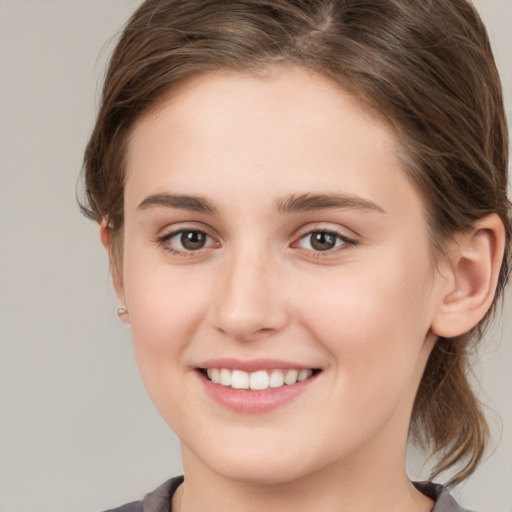 Joyful white young-adult female with medium  brown hair and grey eyes