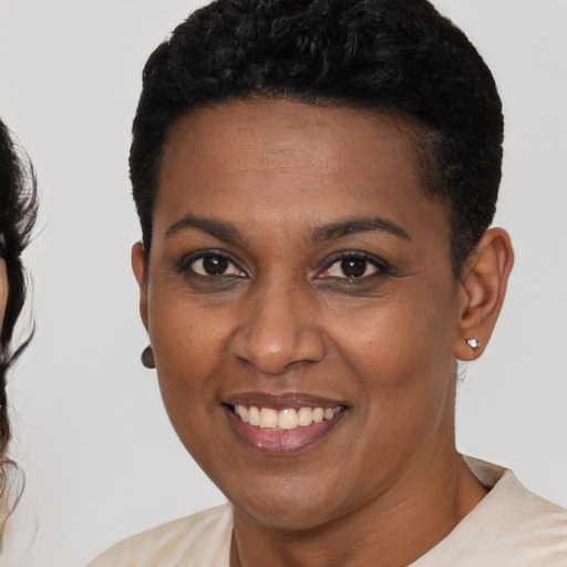 Joyful black young-adult female with short  black hair and brown eyes