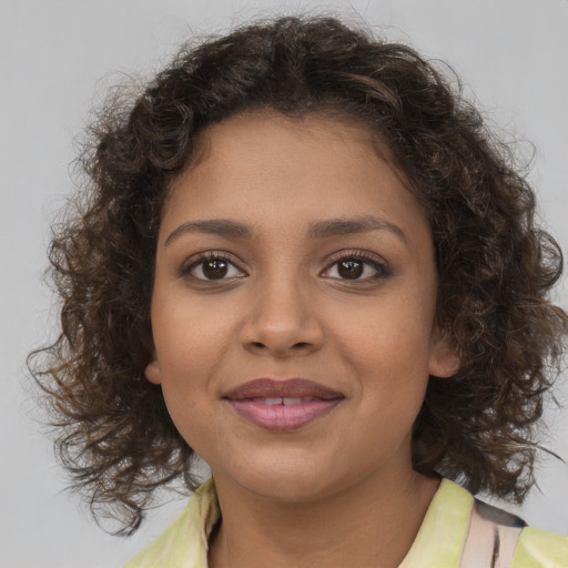 Joyful black young-adult female with medium  brown hair and brown eyes