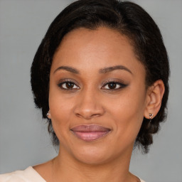 Joyful black young-adult female with medium  brown hair and brown eyes