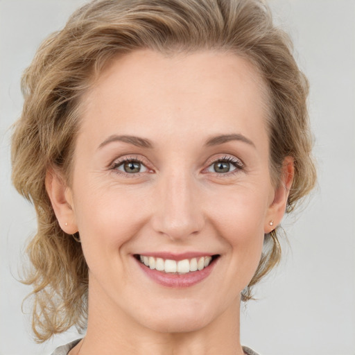 Joyful white young-adult female with medium  brown hair and blue eyes