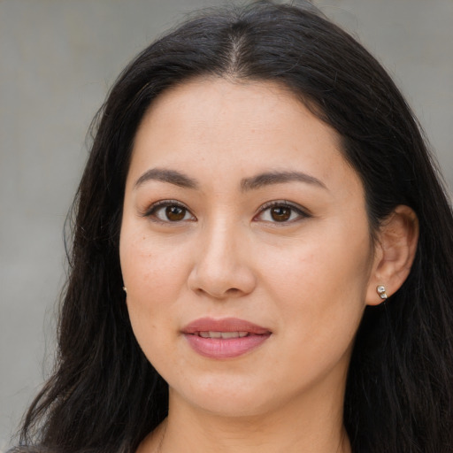 Joyful latino young-adult female with long  brown hair and brown eyes