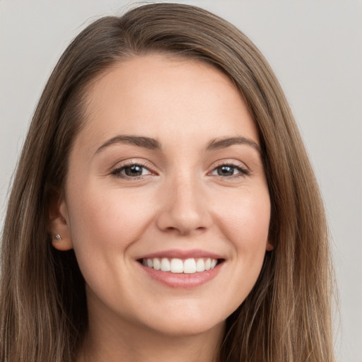 Joyful white young-adult female with long  brown hair and brown eyes