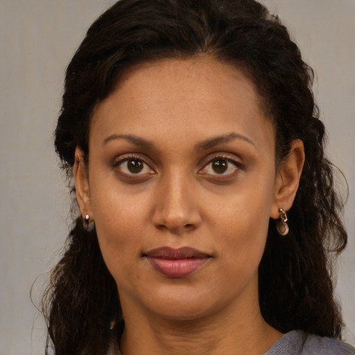 Joyful latino adult female with long  brown hair and brown eyes