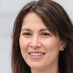 Joyful white adult female with long  brown hair and brown eyes