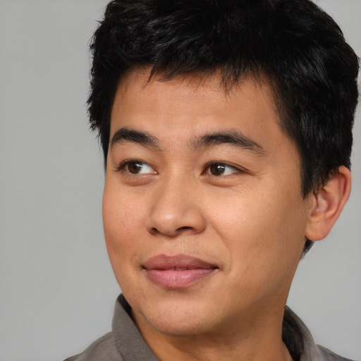 Joyful asian young-adult male with short  brown hair and brown eyes