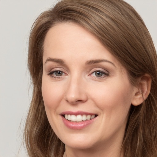 Joyful white young-adult female with long  brown hair and brown eyes