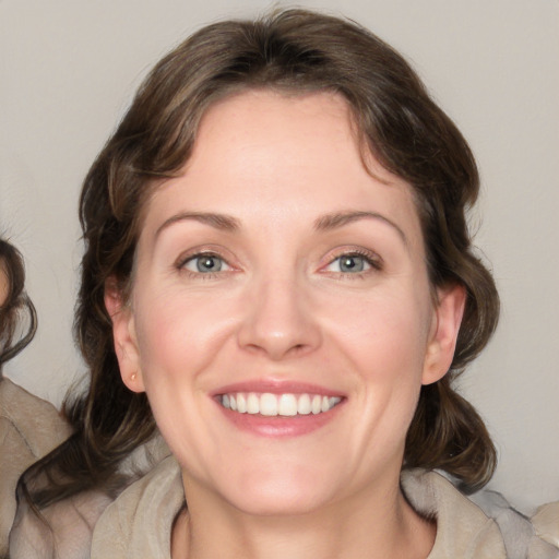 Joyful white adult female with medium  brown hair and green eyes