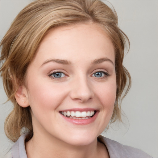 Joyful white young-adult female with medium  brown hair and blue eyes