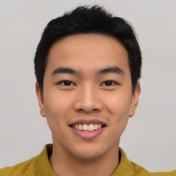 Joyful asian young-adult male with short  black hair and brown eyes