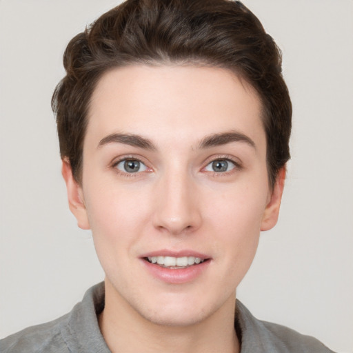 Joyful white young-adult female with short  brown hair and grey eyes