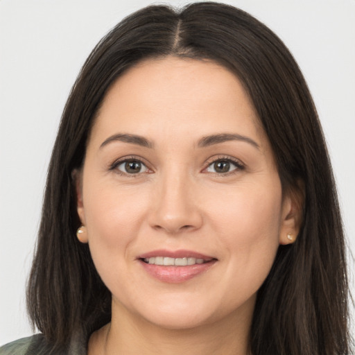 Joyful white young-adult female with long  brown hair and brown eyes