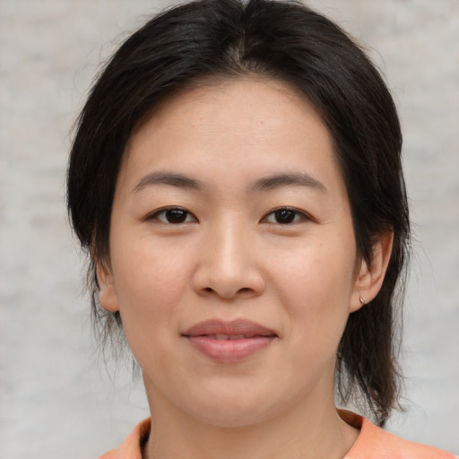 Joyful asian young-adult female with medium  brown hair and brown eyes