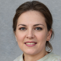 Joyful white young-adult female with medium  brown hair and grey eyes