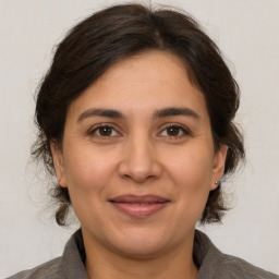 Joyful white adult female with medium  brown hair and brown eyes