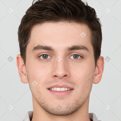 Joyful white young-adult male with short  brown hair and grey eyes