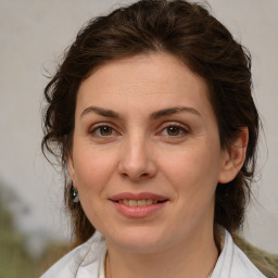 Joyful white young-adult female with medium  brown hair and green eyes