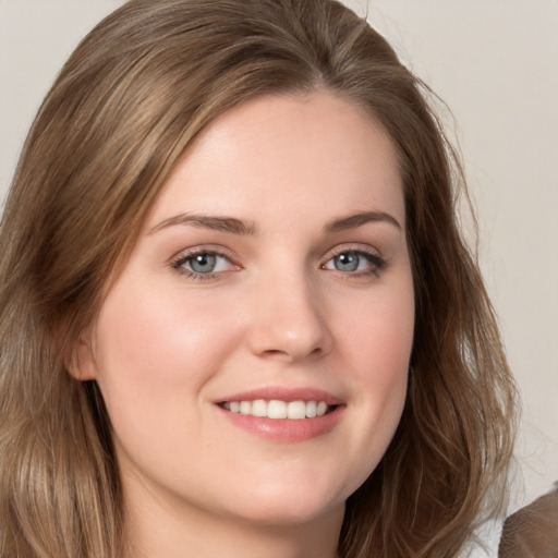 Joyful white young-adult female with long  brown hair and grey eyes