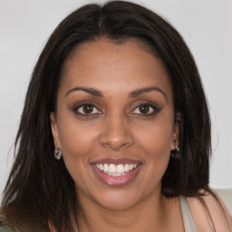 Joyful black young-adult female with long  brown hair and brown eyes