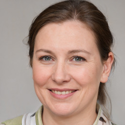 Joyful white adult female with medium  brown hair and blue eyes