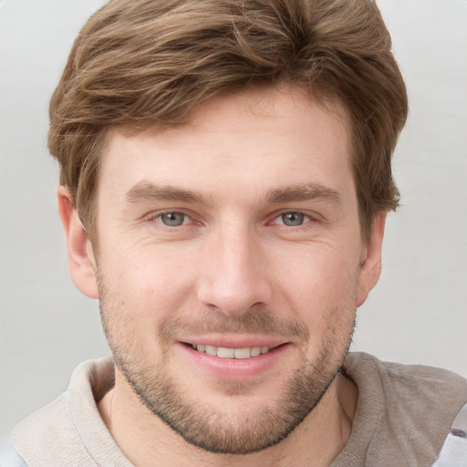 Joyful white young-adult male with short  brown hair and grey eyes