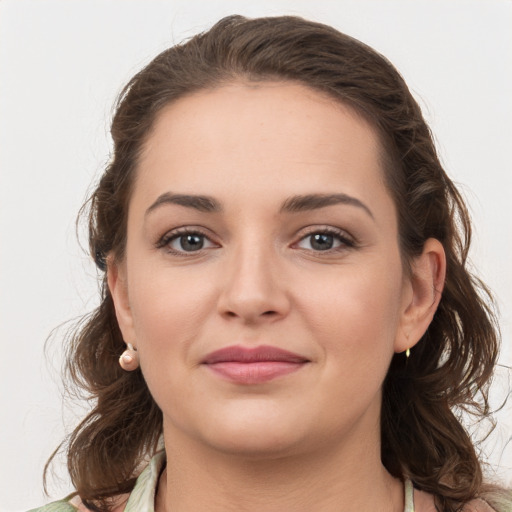 Joyful white young-adult female with medium  brown hair and grey eyes