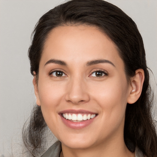 Joyful white young-adult female with long  brown hair and brown eyes