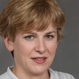 Joyful white adult female with medium  brown hair and blue eyes