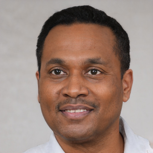 Joyful black young-adult male with short  black hair and brown eyes