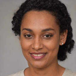 Joyful black young-adult female with medium  brown hair and brown eyes