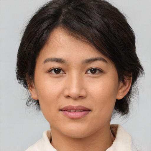 Joyful asian young-adult female with medium  brown hair and brown eyes