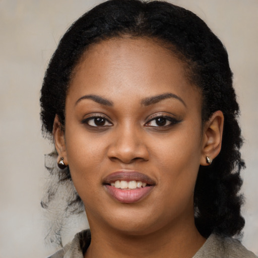 Joyful black young-adult female with long  black hair and brown eyes