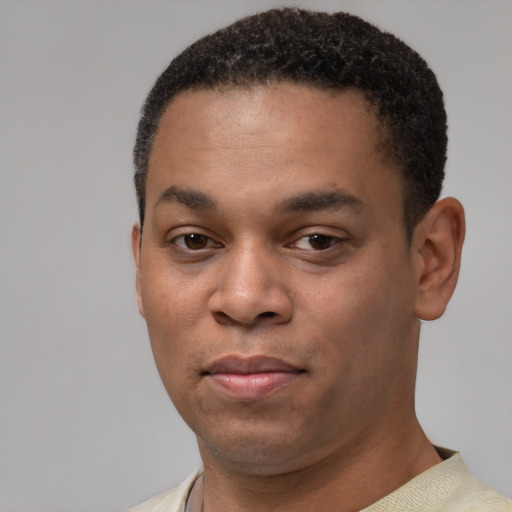Joyful black young-adult male with short  black hair and brown eyes