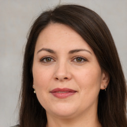 Joyful white adult female with long  brown hair and brown eyes