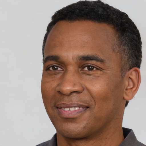 Joyful black young-adult male with short  black hair and brown eyes