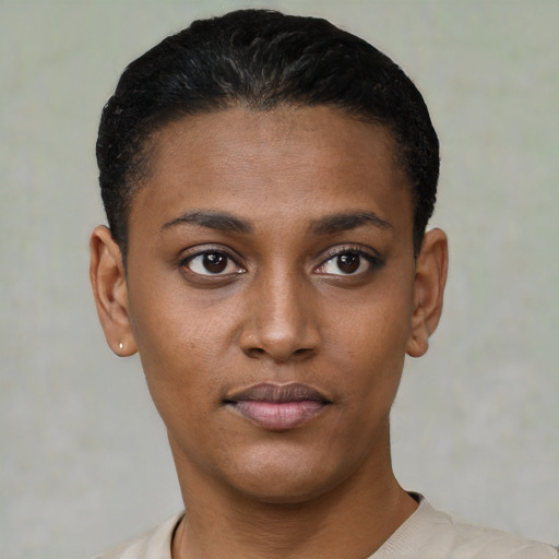Joyful black young-adult female with short  black hair and brown eyes