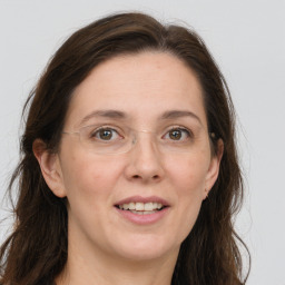 Joyful white adult female with long  brown hair and grey eyes