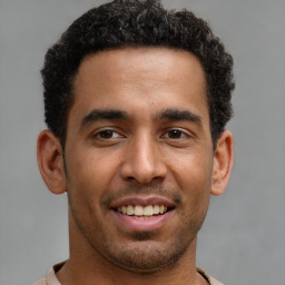 Joyful latino young-adult male with short  brown hair and brown eyes