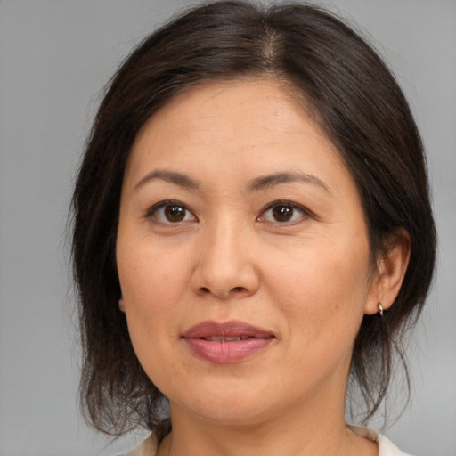 Joyful asian adult female with medium  brown hair and brown eyes