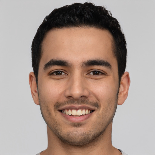 Joyful latino young-adult male with short  black hair and brown eyes