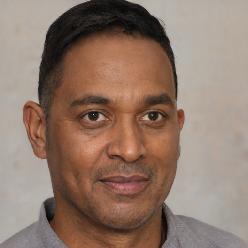 Joyful black adult male with short  brown hair and brown eyes