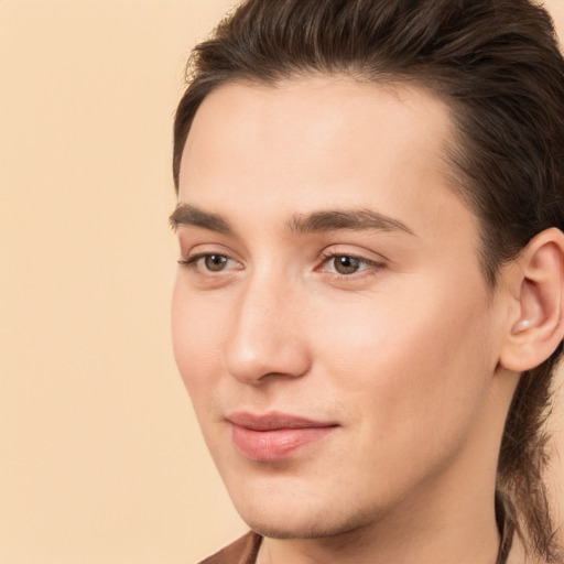 Joyful white young-adult male with long  brown hair and brown eyes