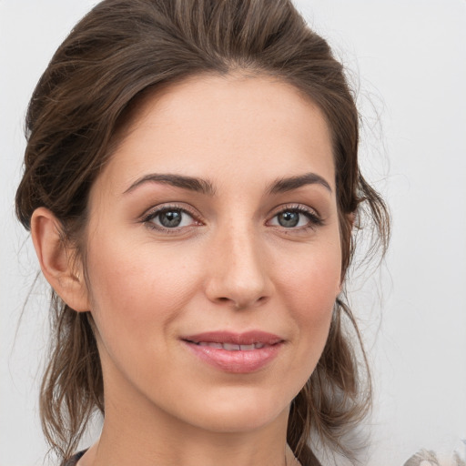 Joyful white young-adult female with medium  brown hair and grey eyes