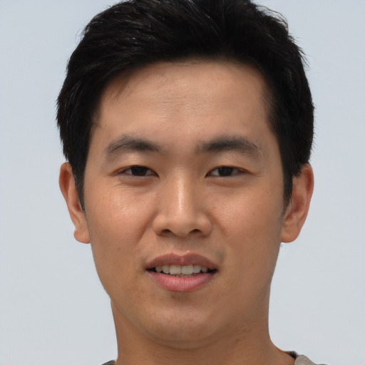 Joyful asian young-adult male with short  black hair and brown eyes