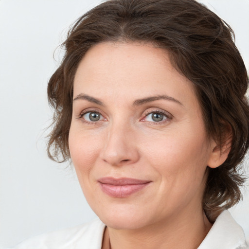 Joyful white adult female with medium  brown hair and green eyes