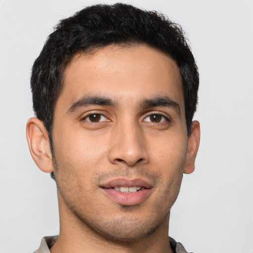 Joyful latino young-adult male with short  brown hair and brown eyes