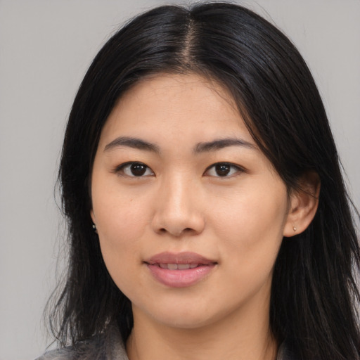 Joyful asian young-adult female with long  brown hair and brown eyes