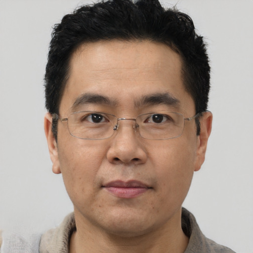 Joyful asian adult male with short  brown hair and brown eyes